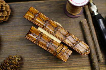 Tan patina alligator leather watch straps with crocodile texture on rustic wooden background - handmade vintage watch bands