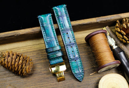 Teal alligator leather watch strap with gold deployant clasp on wooden background - handmade luxury watch band