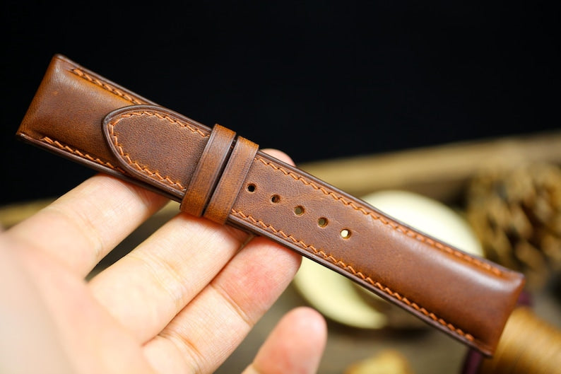 Close-up of brown Vachetta leather watch strap texture with hand-stitching detail - premium Italian leather band